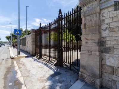 � composto da un massiccio cancello in ferro tra due colonne in pietra...